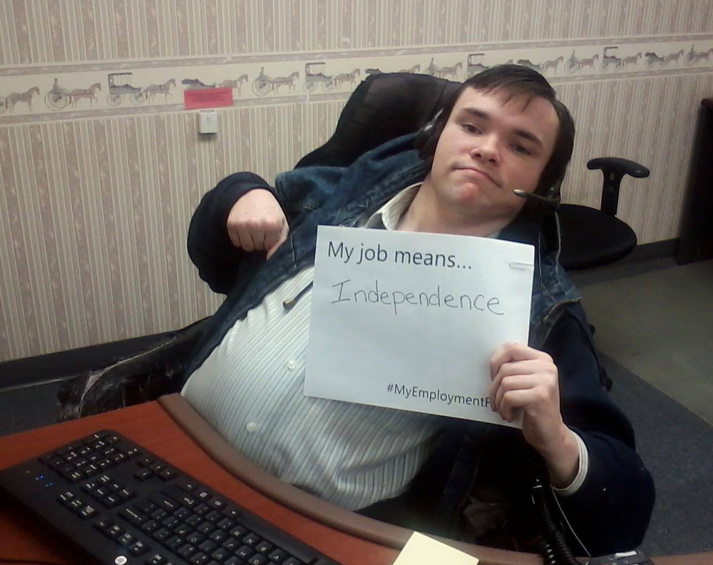 A man at work holding up a sign saying what his job means to him