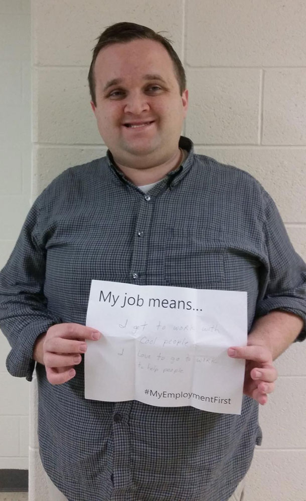 Man holding up a sign saying what his job means to him