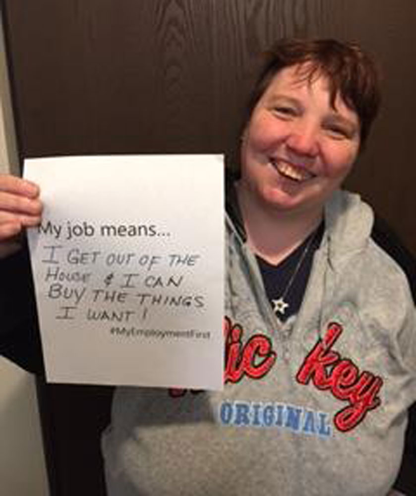 Woman holding up a sign saying what her job means for her